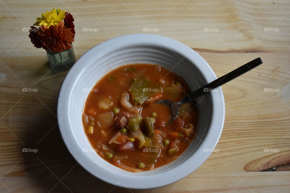 a bowl of hot vegetable soup on a cold rainy day