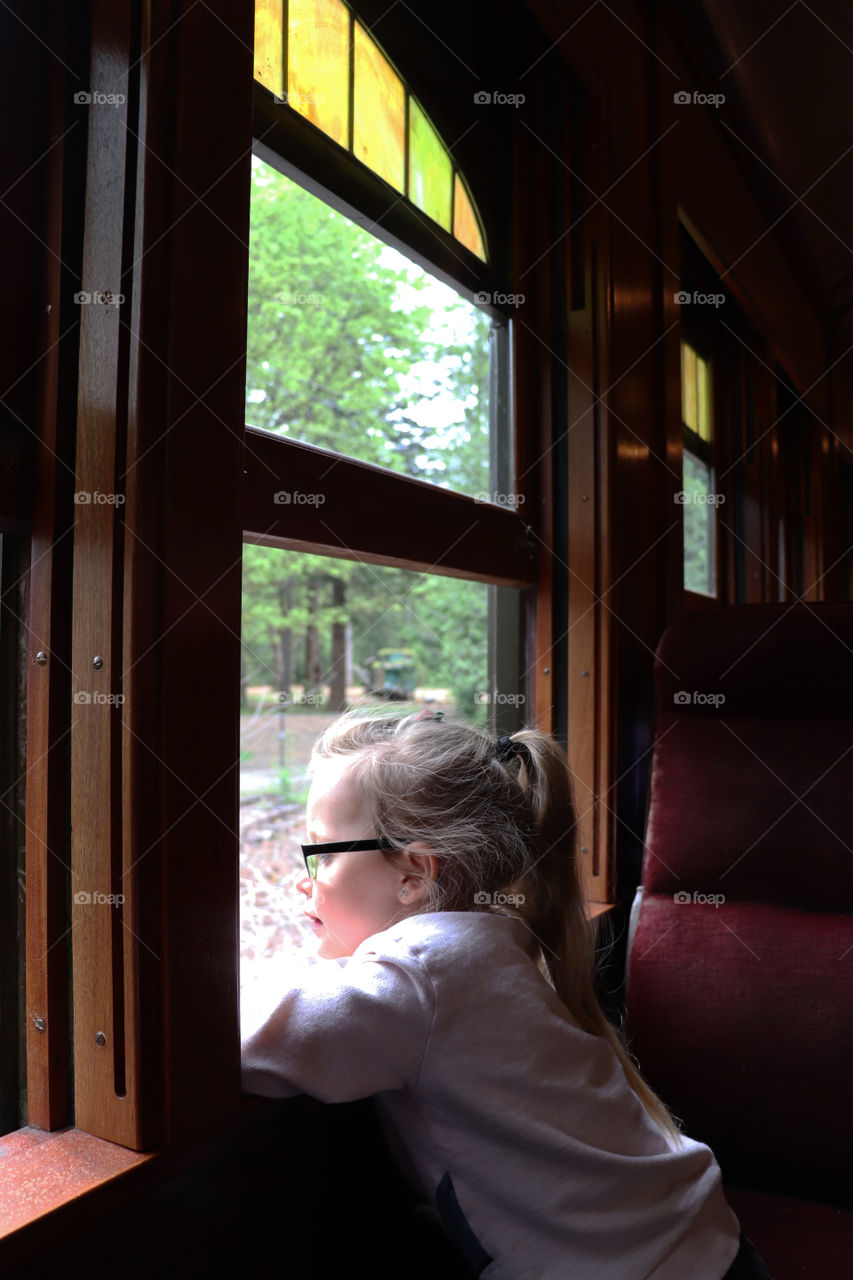 Child looking out the window of an old train