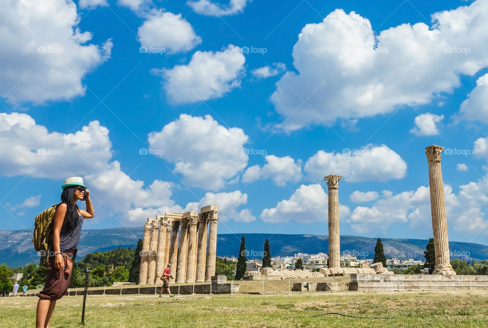 Young woman standing near ancient column