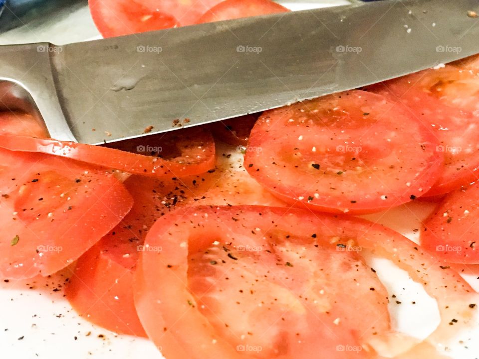 Sliced tomatoes knife on cutting board closeup