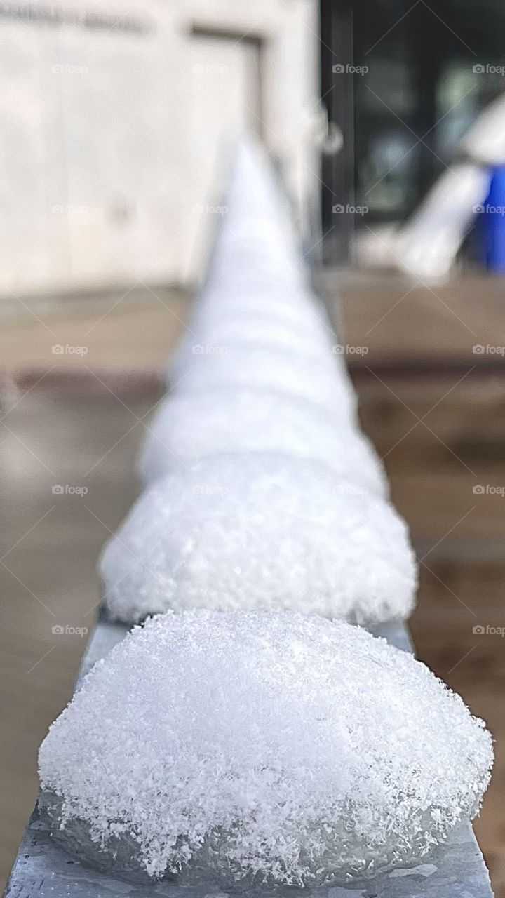 The ice balls queue up on a metal fence