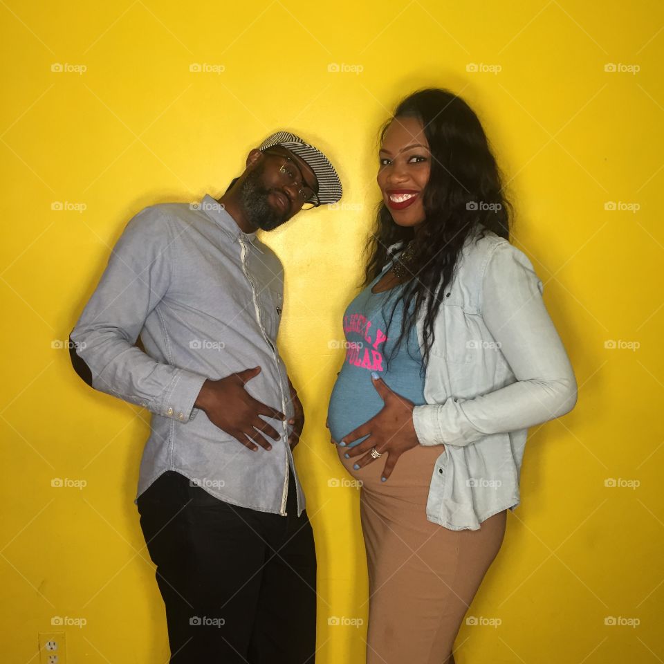 5 Months Pregnant . My wife and I on a yellow wall selfie picture on a timer