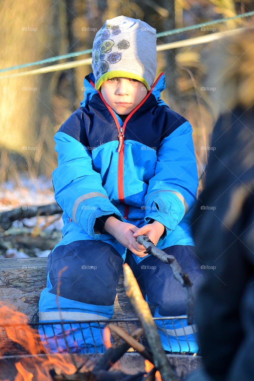 Boy at the fire outdoors