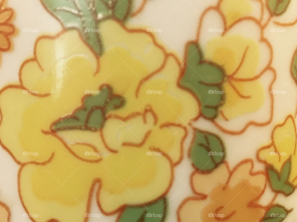 Closeup of yellow flower on coffee mug.