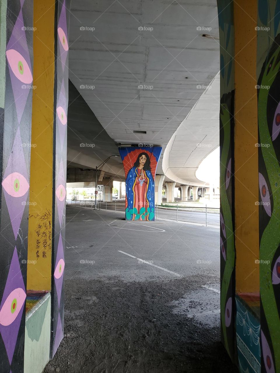 Colorful urban street art under a highway.