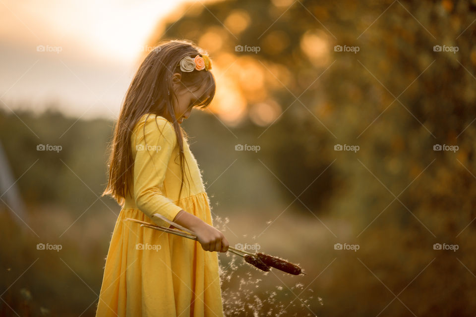 Little girl in yellow dress outdoor portrait at sunset 