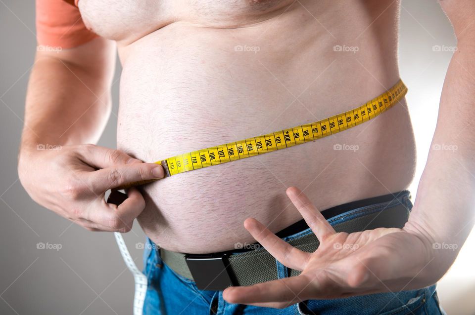 A man measures his fat belly