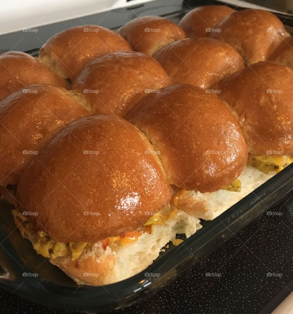 Pan of breakfast sliders hot out if the oven. Omelet, bacon and cheese pull apart sandwiches. 