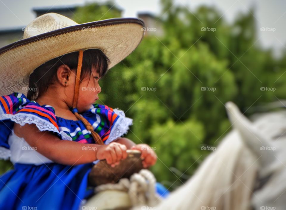 Young Girl Riding A Horse. Mexican Girl In Colorful Dress Riding A White Horse
