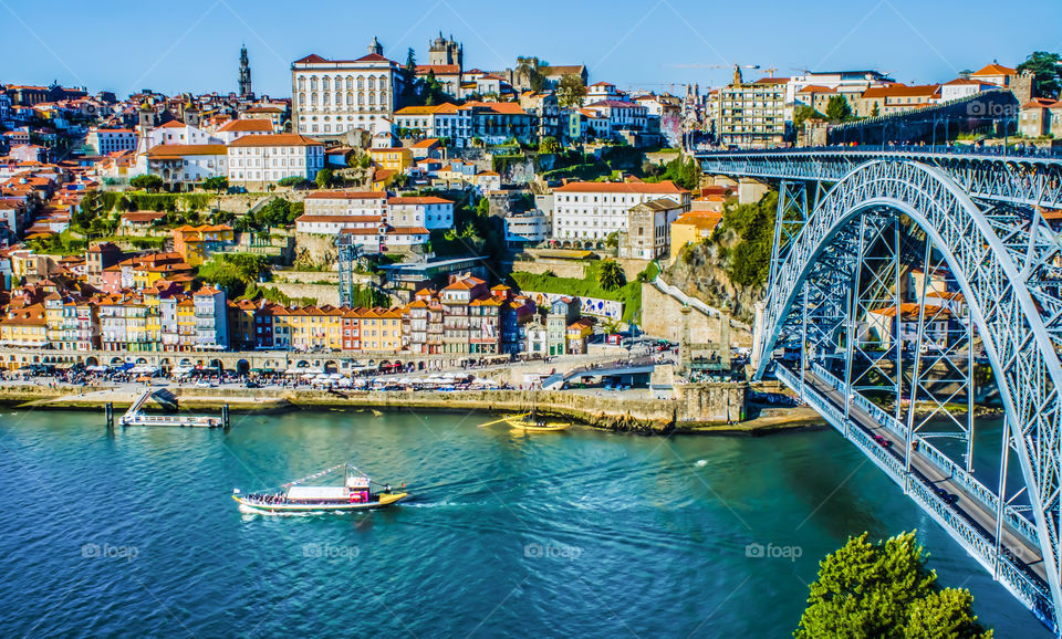 The magically, beautiful city of Porto on the Douro river, along side the Luís I bridge, on a bright and clear day.
