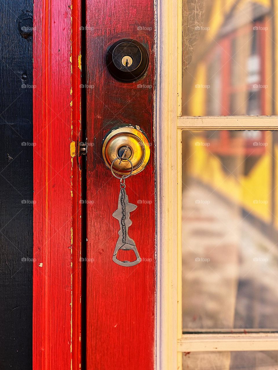 Key in the door, key with keyring in the door, unlocking doors with keys, bright red door of an AirBNB