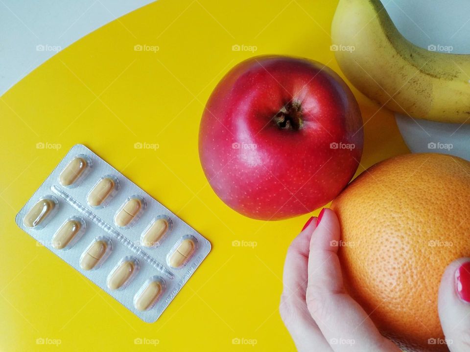 vitamins pills and fresh fruits in the female hand healthy lifestyle