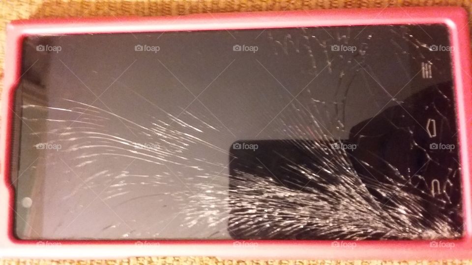 smashed phone screen. smart phone with the glass screen broken in a spiderweb pattern
