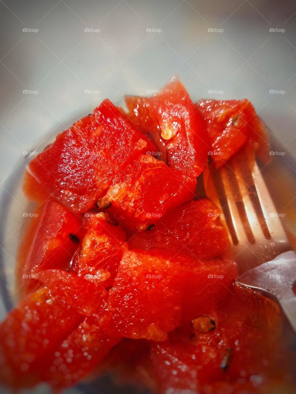 red water melon slices on a bowl with spoon