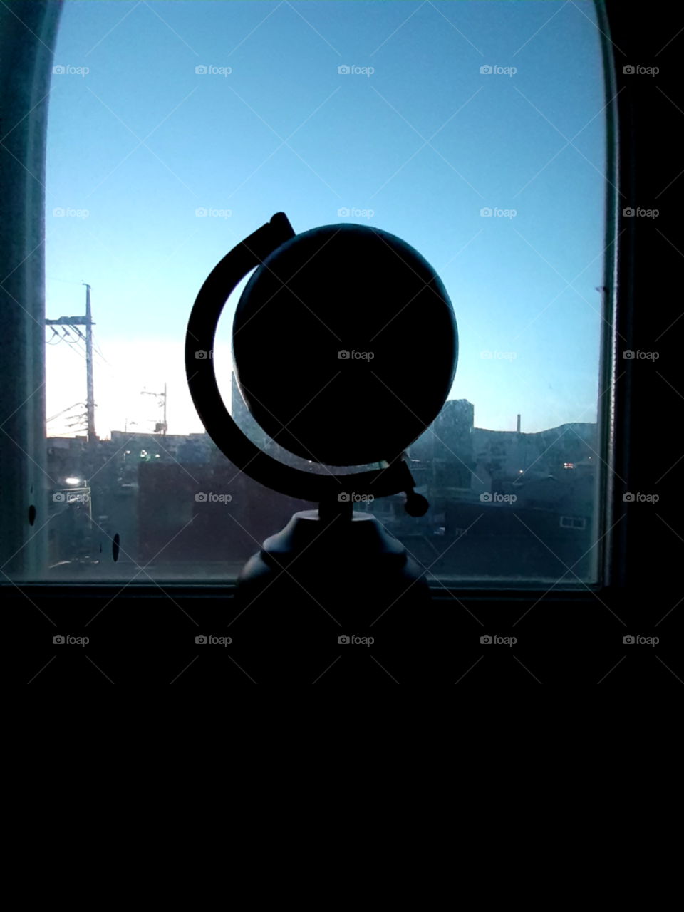 shadow of the globe in the early morning during  the sunrise at our window on the summer time.