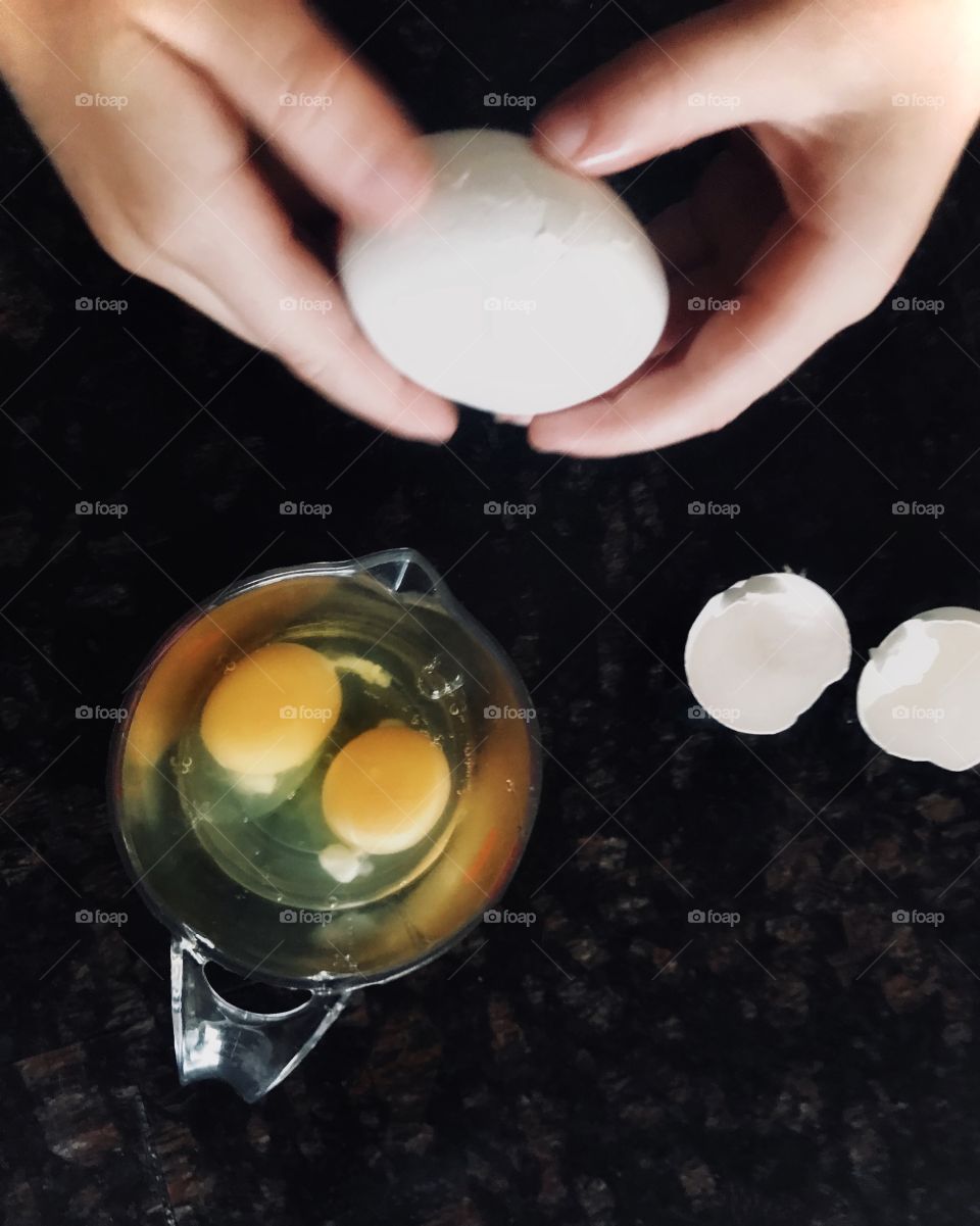 Ariel view of cracking eggs in a bowl and egg shells 