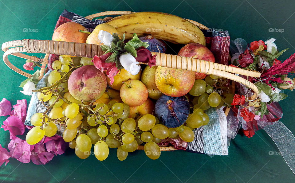 a basket of fresh and various fruits on a green background