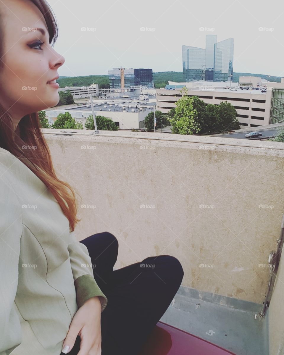 Young woman sitting on terrace of a building
