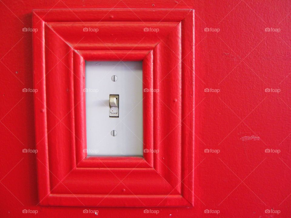 white light switch on a red wall