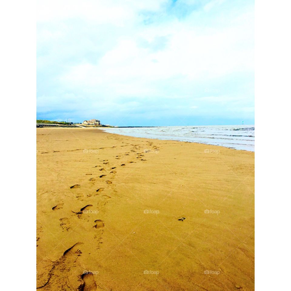 Walking along the beach with nothing but our bare feet, leaving footprints in the sand. 