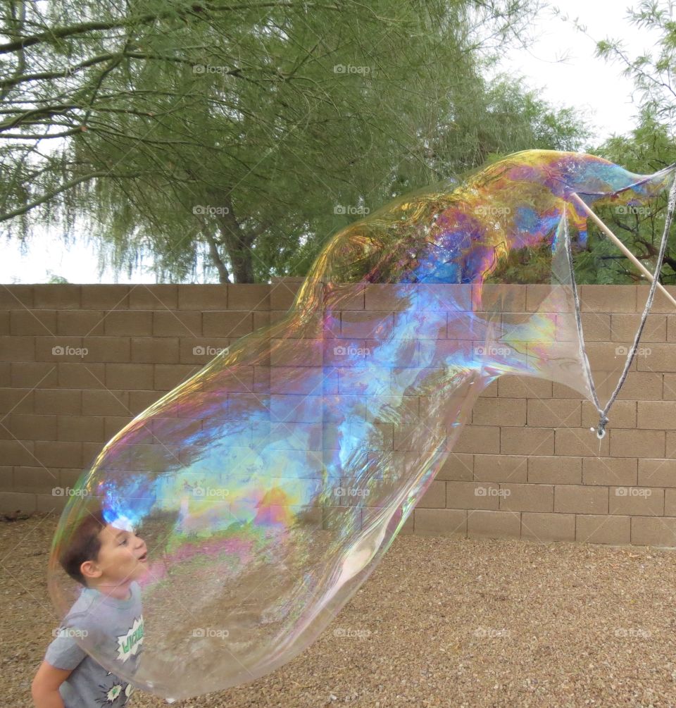 Little boy’s head in a giant bubble.