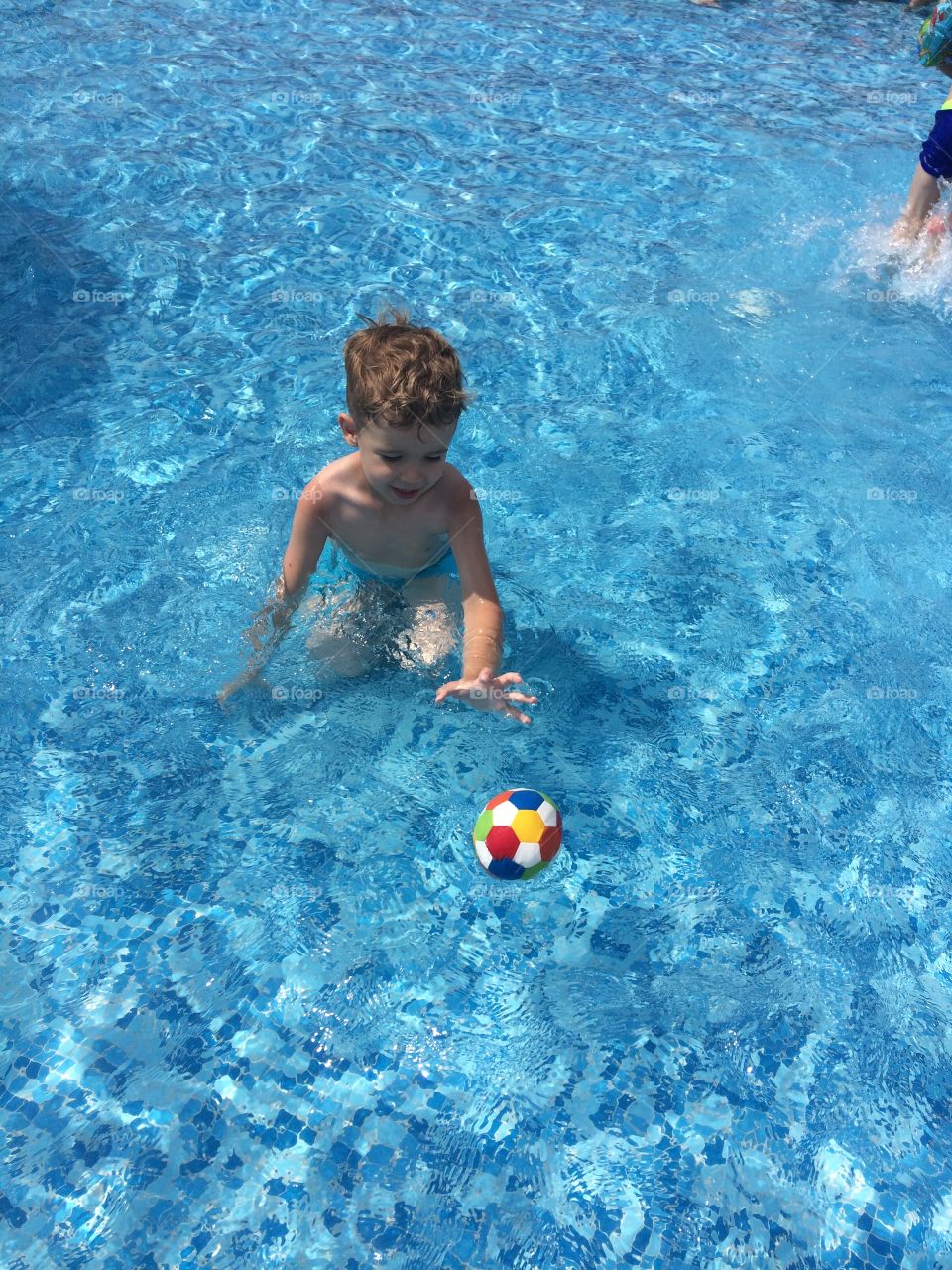 boy swims with a bal
