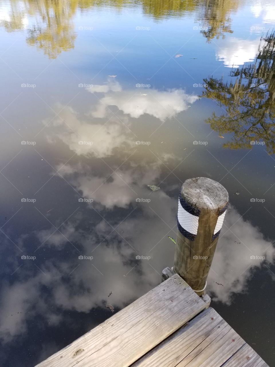 Reflection of clouds by dock