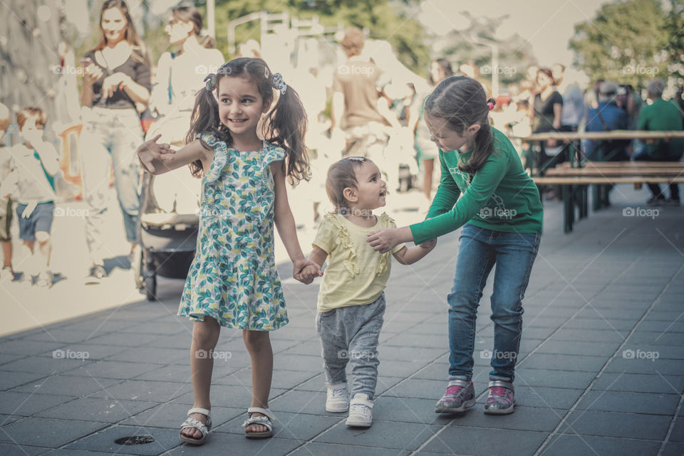  3 kids walking hand in hand 