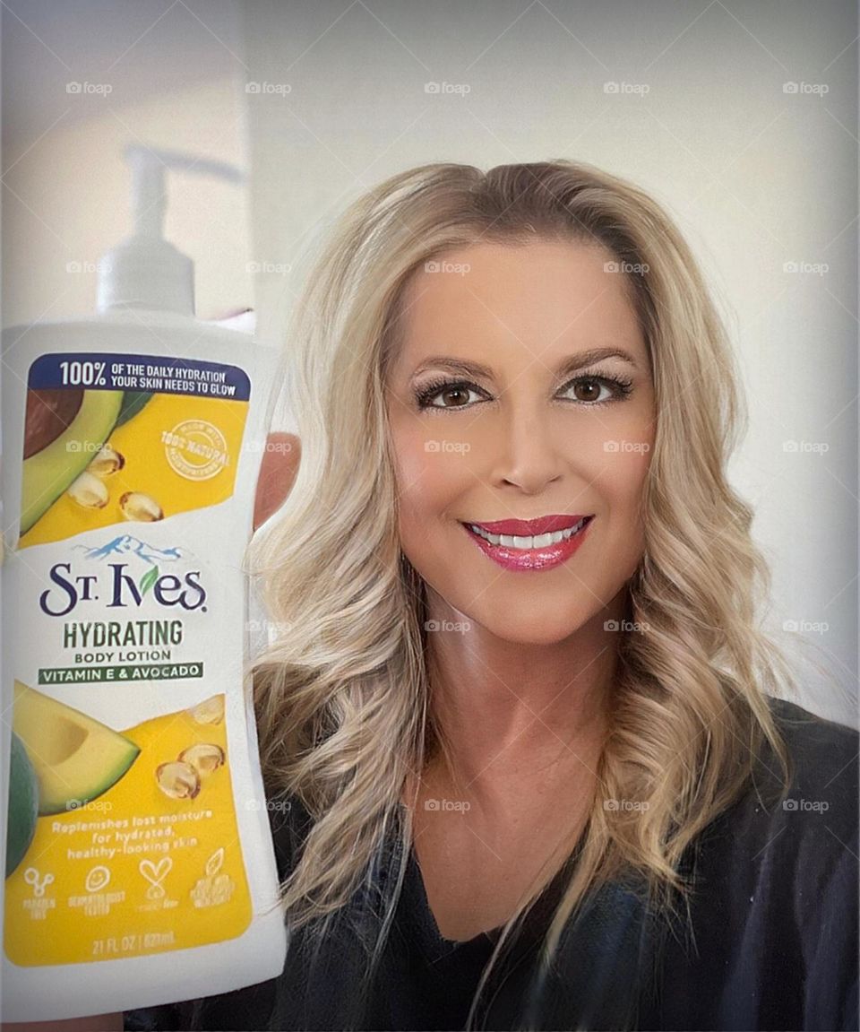 Blonde woman displaying a product.