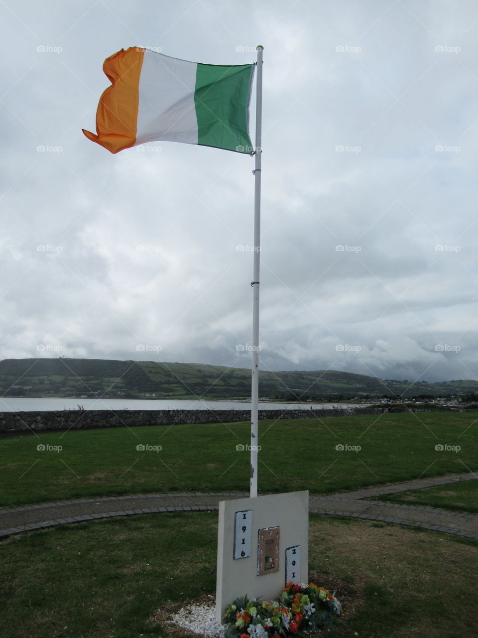 Irish flag blowing in the breeze and memorial stone at carnlough county antrim. 🇮🇪