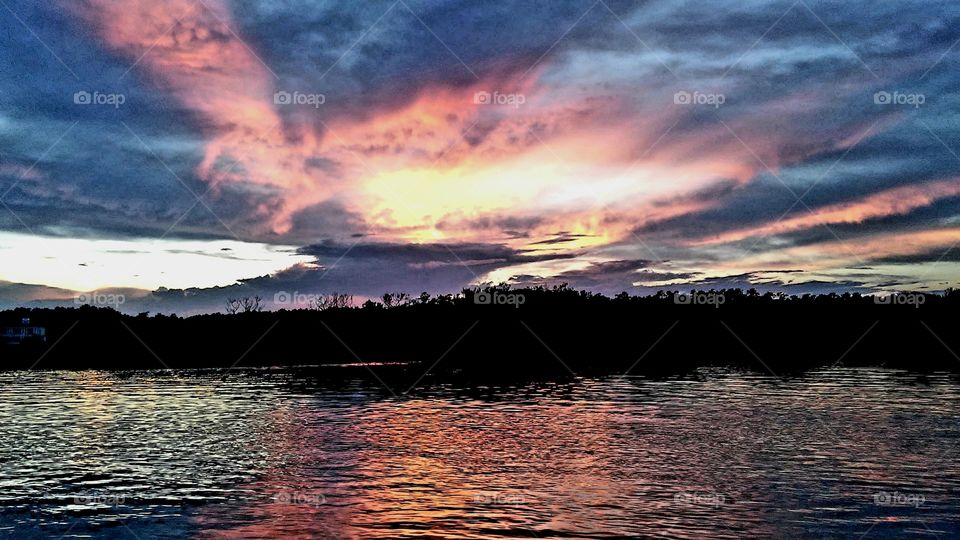 sunset over Pawleys Island, SC salt marsh and bird sanctuary the bright pinks reds and orange look like Pegasus on fire while the beauty of the sunset reflects on the water