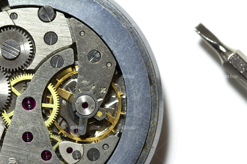 vintage pocket watch and screwdriver on a white background.  watch repair concept