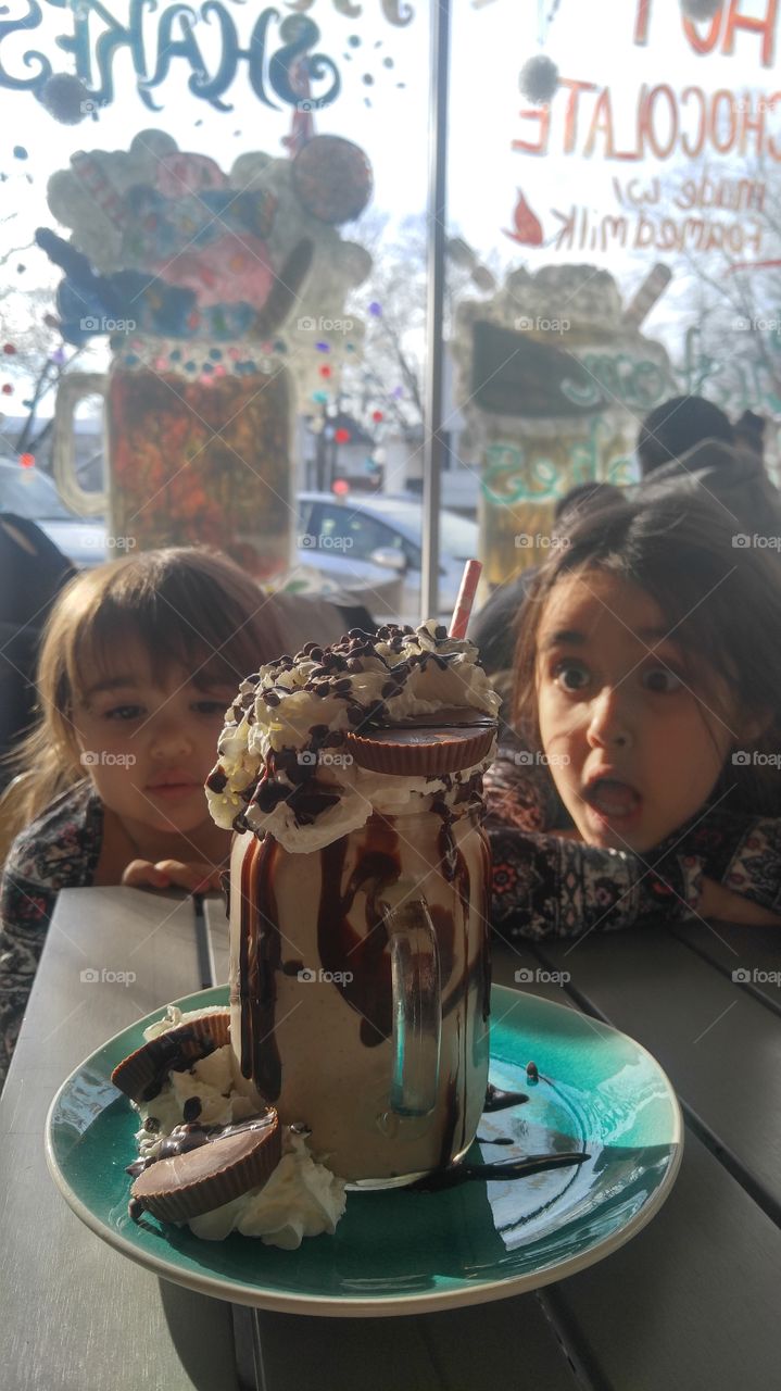 Two girl eating ice cream on table at café