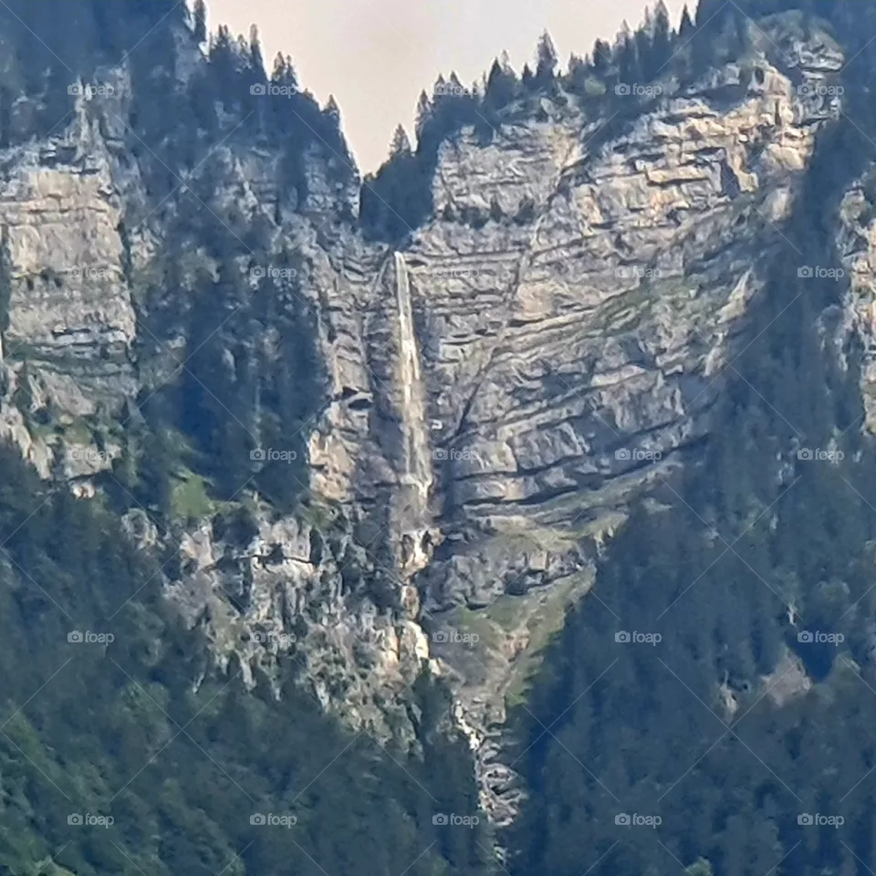 Between the mountains of Austria a waterfall.