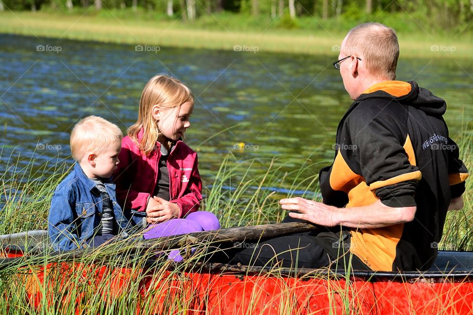 Children with father on boat at lake