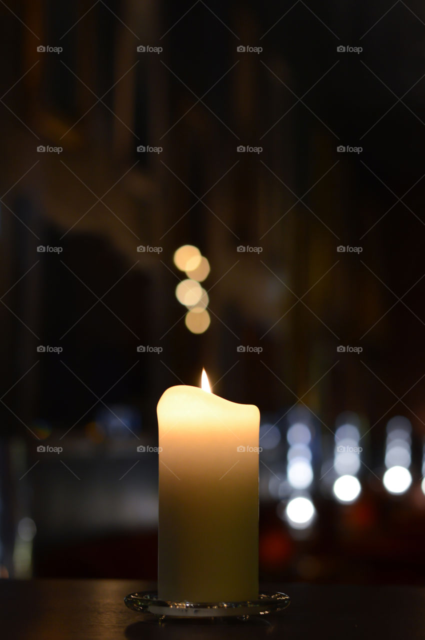 one candle with beautiful bokeh and blurry light reflections
