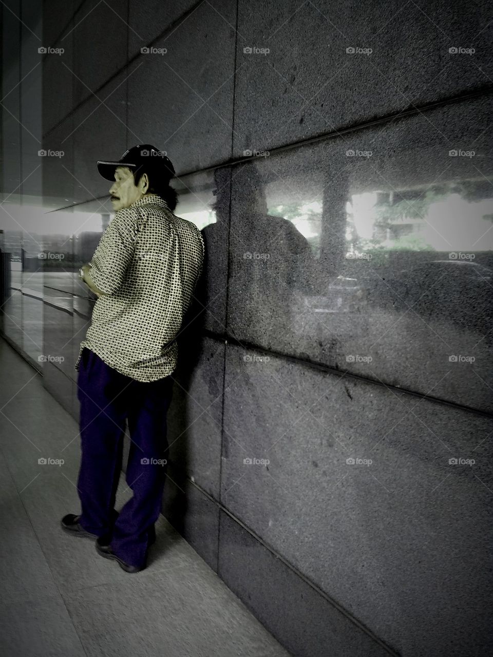 asian man leaning on a wall