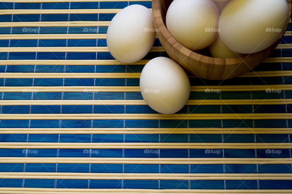 ehite eggs in a stripped blue table. morning light