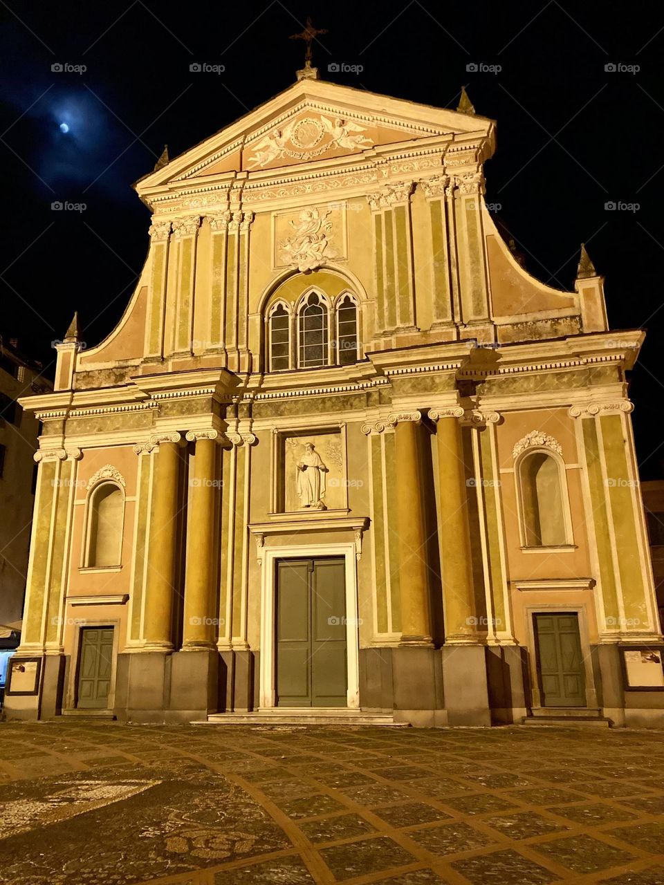 The Church of Saint Anthony Abbott in Dolceacqua, Italy with the partially hidden full moon over its shoulder.