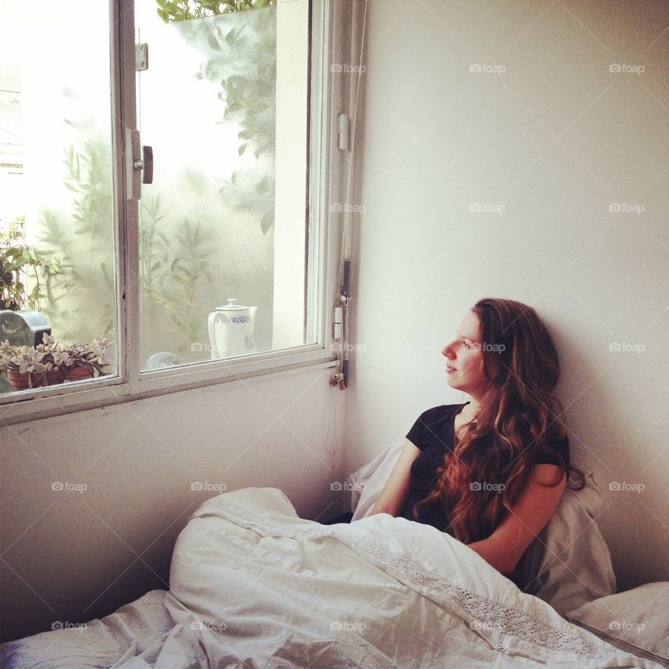 Girl on white bright bedroom 