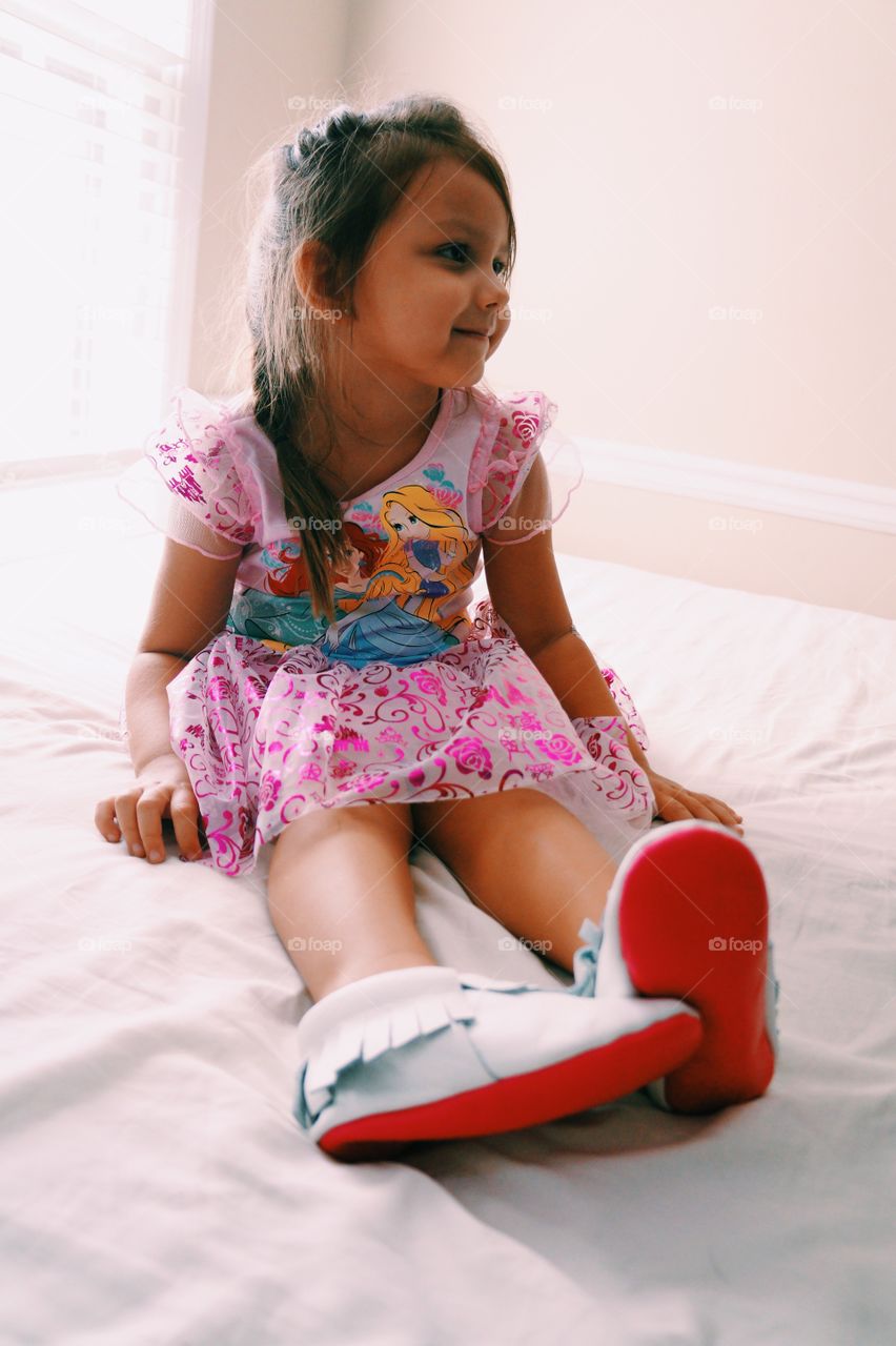 Cute girl sitting on bed