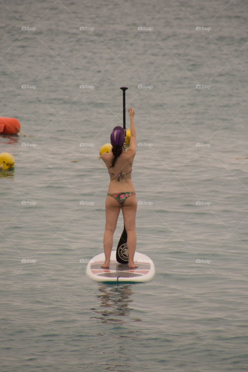 A woman doing some paddle surfing in the ocean