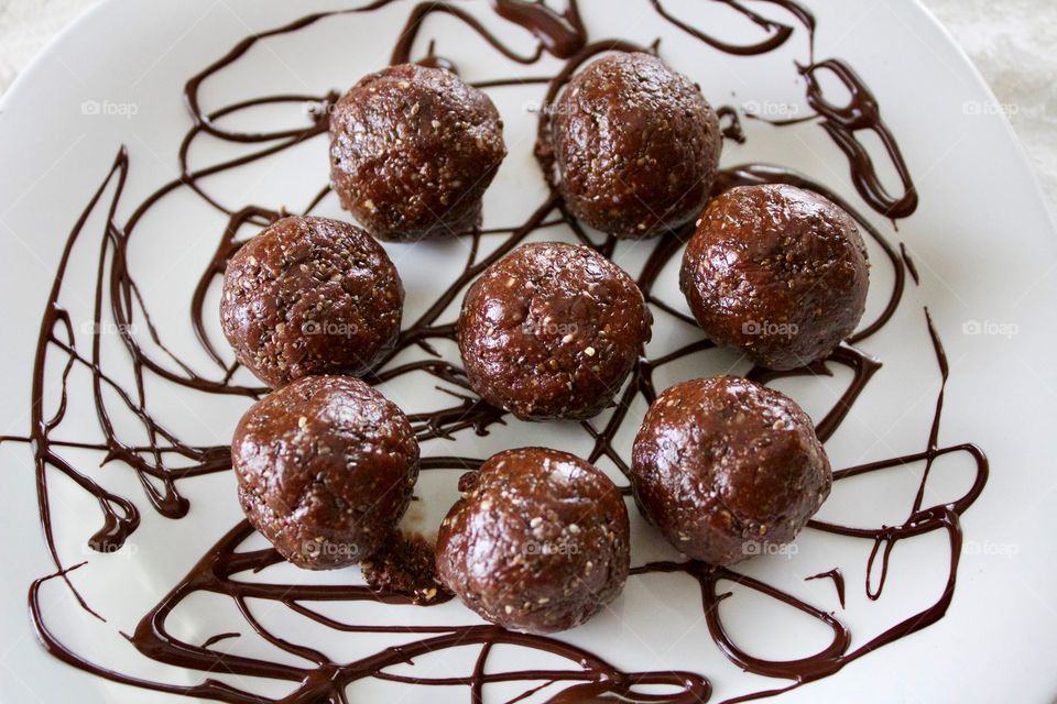 More Chocolate - Nut Butter Cocoa Bites on white plate with chocolate drizzle 
