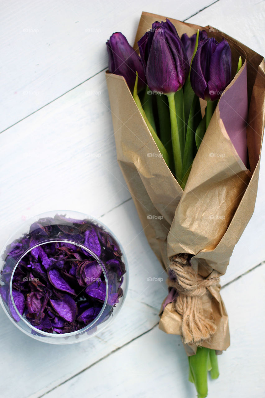 A bouquet of tulips and purple rose petals: congratulations, March 8 (International Women's Day), February 14th (Valentine's Day), holiday