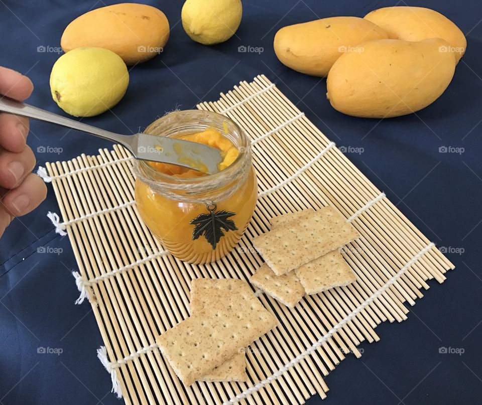 Mango jam with crackers on bamboo plate mat 