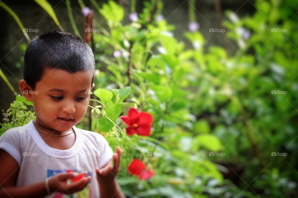 Baby boy playing with flower