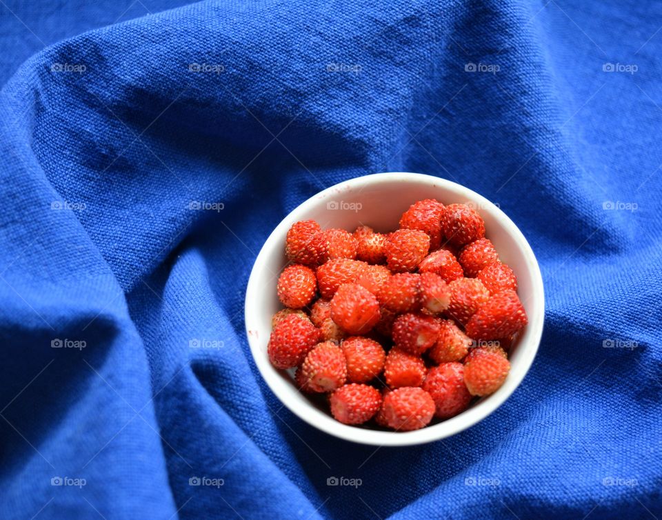 red strawberries on a plate tasty healthy summer food blue background