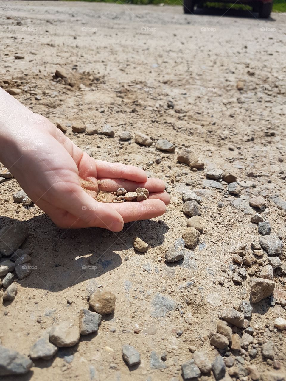 kids hand with little stones