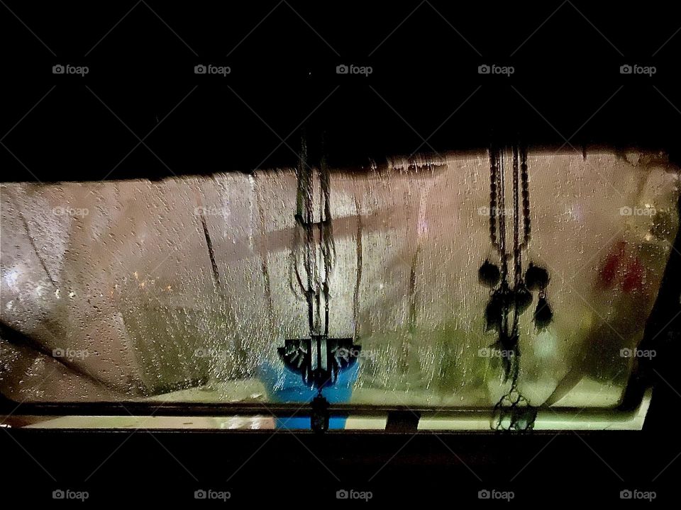 Night is upon us at our “28 foot 1969 Luhrs” at “Newtown Creek” by the “Pulaski Bridge” in LIC, Queens. Illumination from outside casts shadows onto the window and condensation and raindrops running down add to the allure. 2023. Hypnotic Productions