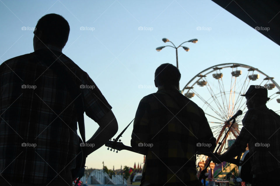 silhouette of band playing set at fair